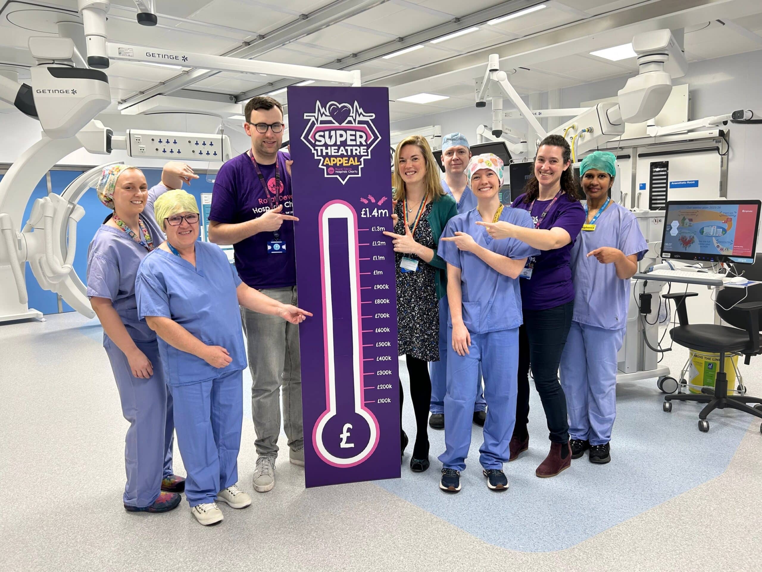 Theatres and charity staff celebrate hitting the £1.4m fundraising target in the new Super Theatre at the Royal Devon and Exeter Hospital.